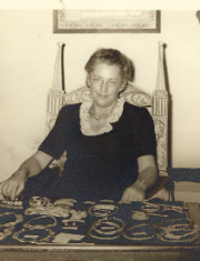 Olga (Pollak) Weil at a Connecticut crafts show with some of her knotted jewelry. She may have made her collar as well.